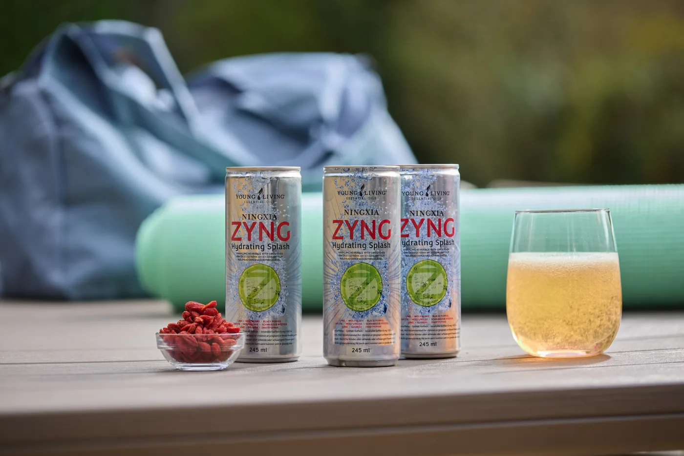 Drei Dosen NingXia Zyng mit einem gefüllten Glas und getrockneten Wolfsbeeren